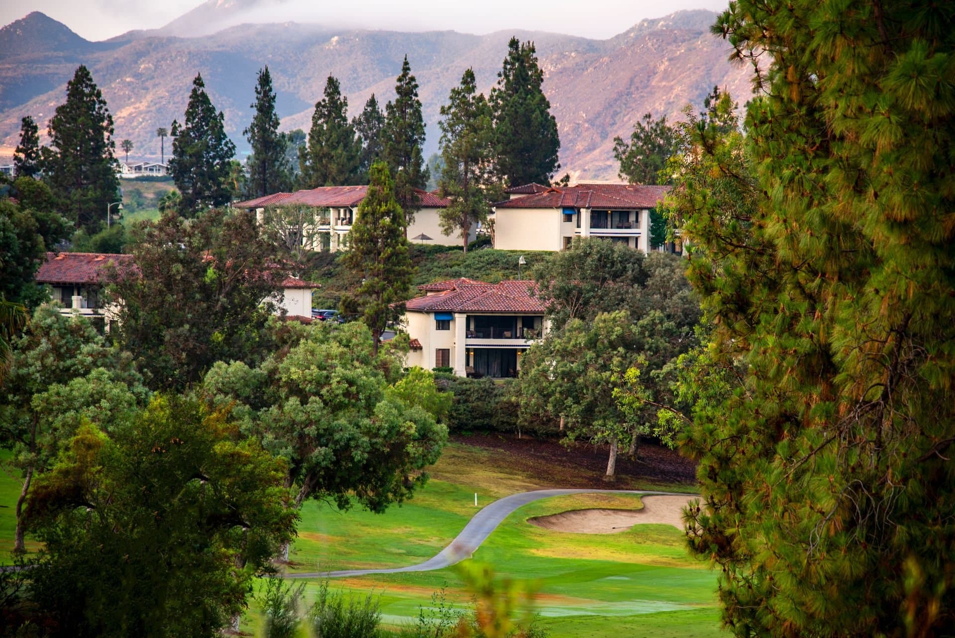 Tile-roofed hillside homes above a green North County valley